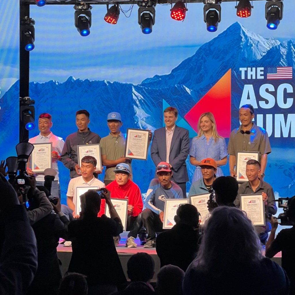 Members of the Everest rope-fixing team holding certificates on stage at the Ascent Summit