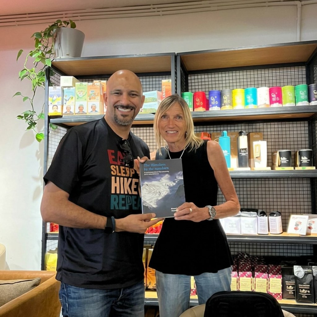 Mohamed Isa and a fellow attendee holding a book in a Kathmandu coffee shop