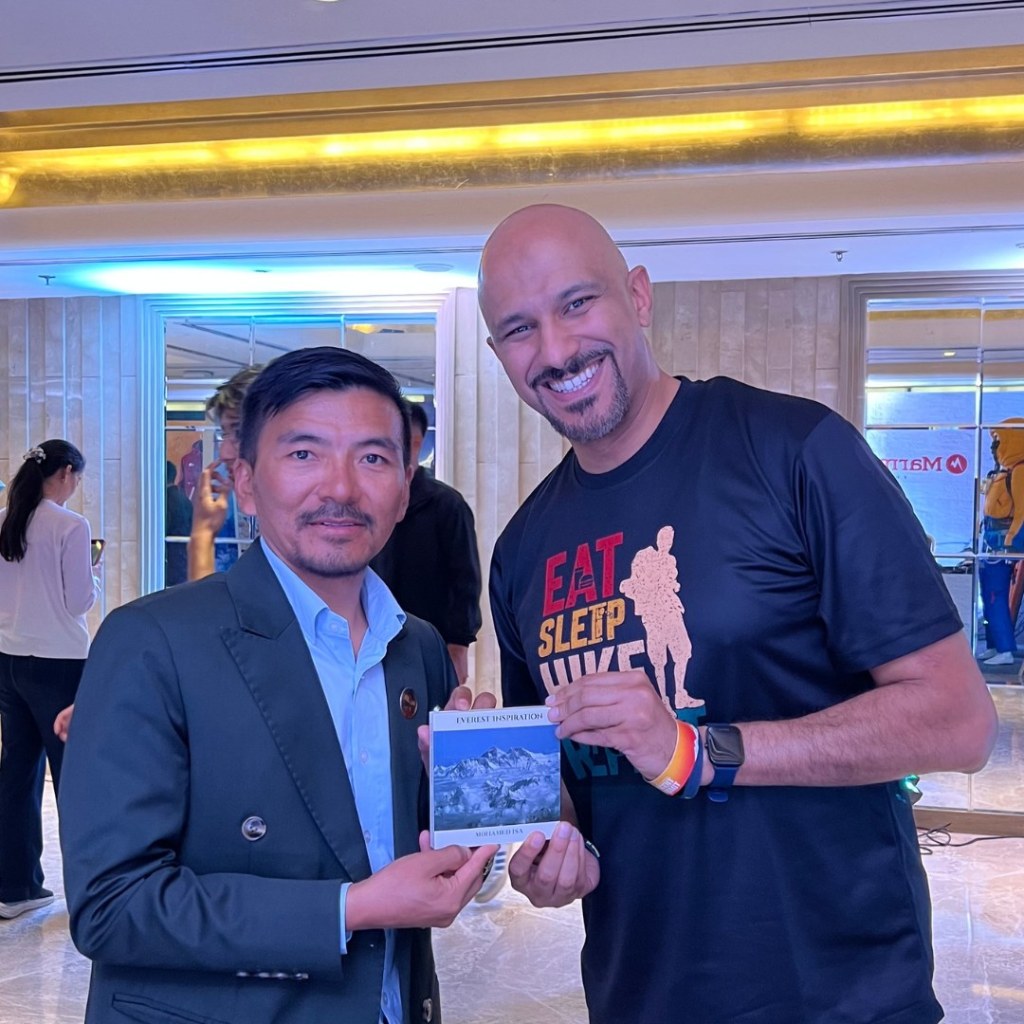 Mohamed Isa with a fellow attendee holding a copy of Everest Inspiration at the Ascent Summit